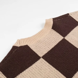 Close-up of ribbed crewneck and brown checkerboard knit texture on the sweater