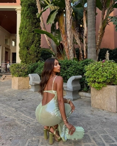 Detail of light green sequined backless dress with matching platform sandals and beaded clutch