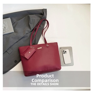 Detail view of burgundy leather tote bag with matching coin purse and gold plaque