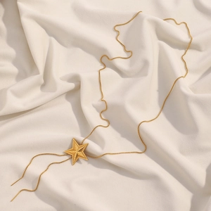 Adjustable 18K gold plated stainless steel necklace with pentagram star pendant on beige cloth