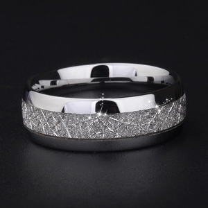 Macro shot of silver stainless steel ring with intricate cross-brushed silk texture