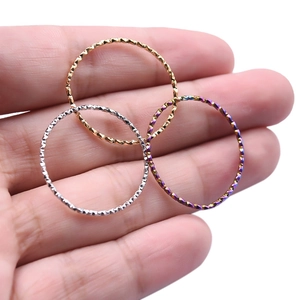 Macro detail of diamond-cut textured metal rings in gold, silver and rainbow colors