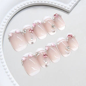 French press-on nails with pink heart rhinestones and pearls on a white beaded tray