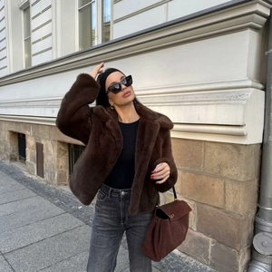 Chic brown short faux fur jacket with lapel collar worn by a model in a street style
