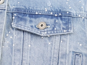 Vue détaillée de la veste en jean bleu clair ornée de strass et de perles de haute qualité