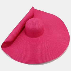 Detail of a large brim fuchsia straw sun hat showing high-density woven spiral texture