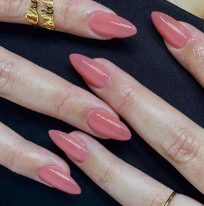 Glossy dusty rose almond press-on nails detail with elegant polished finish on dark background