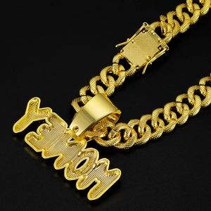 Hip hop gold Cuban chain with iced out Venom letter pendant on a black background