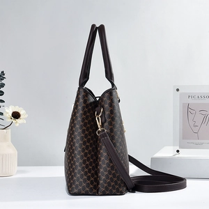 Deep brown monogram patterned handbag with dual handles and shoulder strap shown in side view
