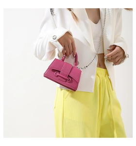 Detail of fuchsia mini crossbody bag with litchi texture leather and silver bead chain