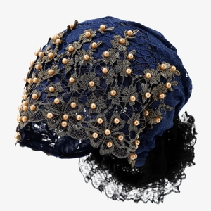 Détail du turban en dentelle ethnique avec broderie dorée et perles décoratives