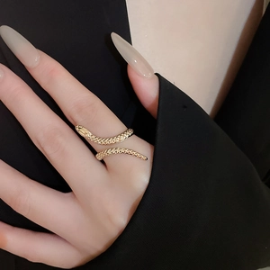 Close-up of a gold snake-shaped ring with scale texture on a model's finger