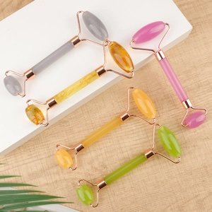 Resin face roller set in five colors with rose gold metal frame on wooden background