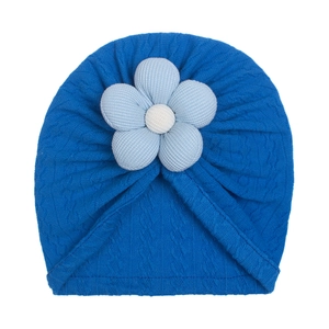 Detail of royal blue baby turban hat featuring a large light blue floral knit ornament