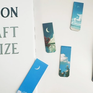 Macro detail of various landscape magnetic bookmarks featuring clouds, moon, and beach