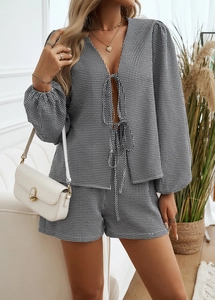 Dettaglio ravvicinato di un completo da casa a righe bianche e nere con cardigan e shorts