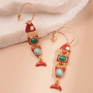 Detail view of gold fishbone tassel earrings with multicolor enamel inlay on stone base