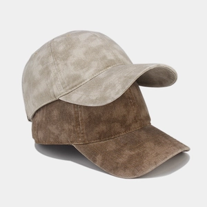 Detail view of washed cotton baseball caps in light beige and brown with retro texture