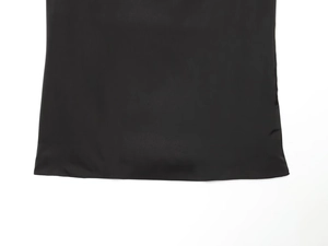 Detail shot of the smooth satin hem on black sleeveless top and trousers set
