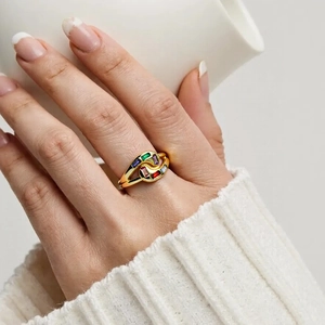 Close-up of golden ring with colorful rectangular zircon stones on a model's finger