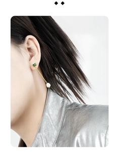 Close-up of elegant S925 silver long drop earrings with green zircon and white pearl