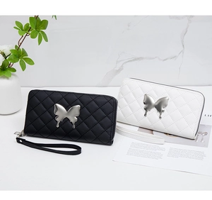 Detail of embroidered rhombic wallet with silver butterfly ornament and wrist strap
