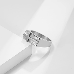 Detailed macro view of silver stainless steel signet ring with cross and sunburst pattern