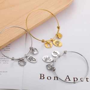 Adjustable wire bracelet with heart, girl silhouette, and floral pendants in gold and silver