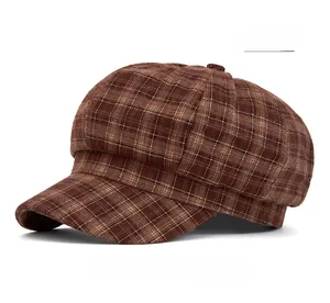 Detail of vintage orange plaid baker boy cap showing thick winter fabric and neat stitching