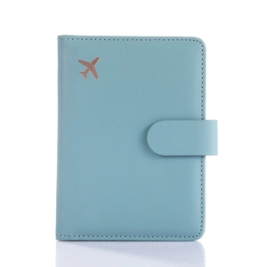 Blue leather passport holder with embossed airplane icon and secure snap button closure