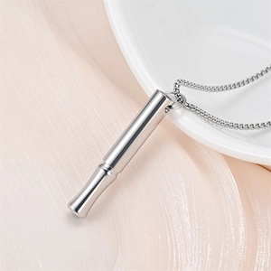 Close-up view of a polished silver meditation breathing necklace pendant with chain