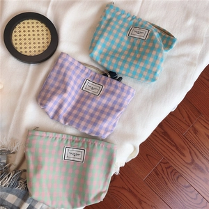 Detail of colorful plaid cotton makeup bags with Time to Party woven labels and zipper