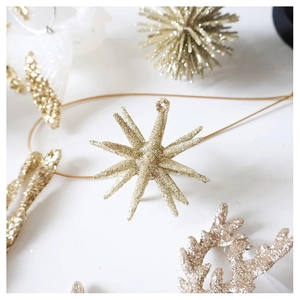 Detailed view of sparkling gold glitter Christmas ornaments featuring star and elk shapes