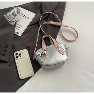 Détail du mini sac à main argenté avec poignées roses et breloque en métal de chien ballon