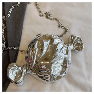 Detail of silver candy-shaped crossbody bag with mirror finish and metallic chain strap