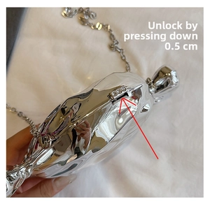 Detail showing the locking mechanism of silver candy shaped crossbody bag with chain strap