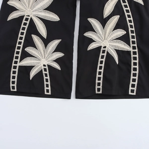 Damenhose im Tropenstil mit weißer Palmenstickerei auf elegantem schwarzem Stoff
