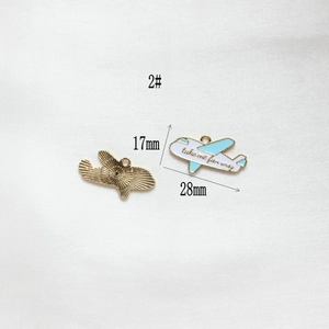 Detailed macro view of gold-plated airplane pendant with blue enamel and dimensions