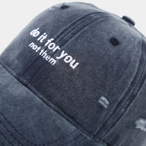 Detailed macro view of vintage washed canvas baseball cap with distressed rip texture