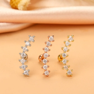 Macro shot of micro-paved zircon curved ear studs in silver, rose gold, and gold finishes