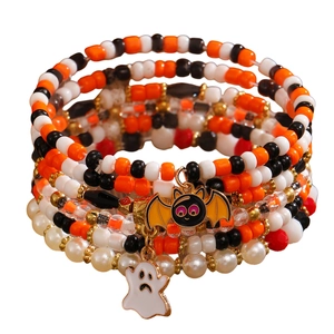 Detail of Halloween beaded bracelet featuring ghost and bat charms with orange and black beads