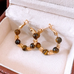 Close-up of 18k gold plated hoop earrings with brown tiger eye beads in a velvet box
