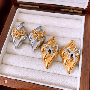 Detail of silver needle bow earrings with textured diamond shape and mixed metal finish