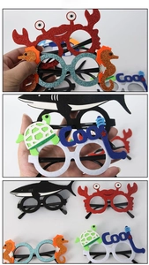 Detail view of colorful glitter ocean theme party glasses with crab and shark designs