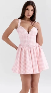 Close-up of pink plaid dress featuring delicate white lace trim and layered puff hemline