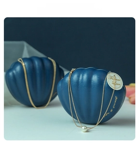 Macro shot of shell-shaped wedding candy boxes with pearl chain and Forever Love tag
