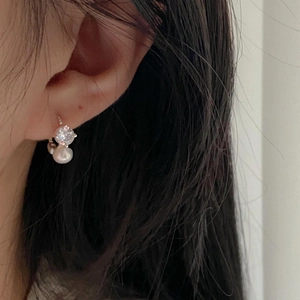 Elegant 925 silver earrings with zircon and pearl drop shown on a model's ear