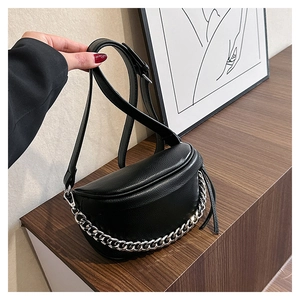 Detail of black crescent crossbody bag featuring lychee texture and bold silver chain