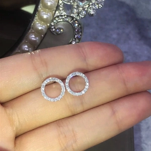 Macro shot of silver-tone circular earrings featuring pavé cubic zirconia settings