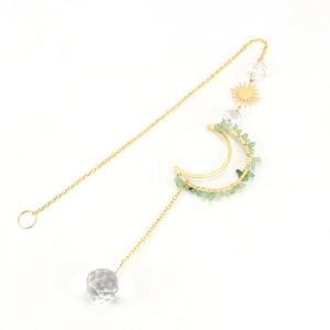 Detail of golden moon suncatcher with green natural stones and a faceted crystal ball